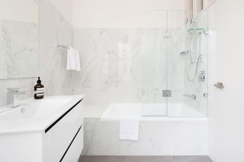 悉尼STUNNING SYDNEY HOME 10的带淋浴和盥洗盆的白色浴室