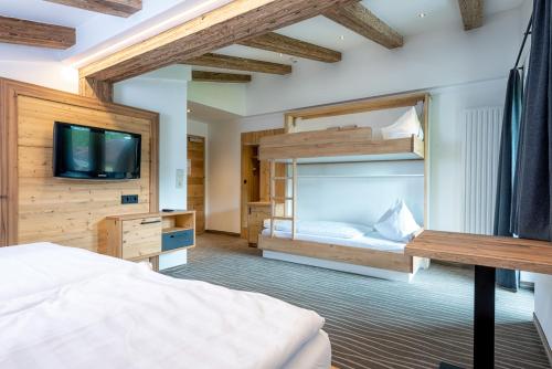 莱奥冈Pension Restaurant Dorfalm的一间卧室配有双层床和电视。