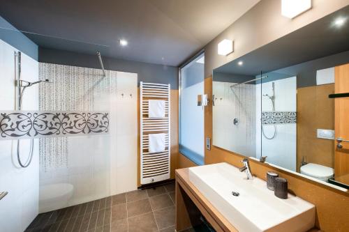 拉古多ALIA appartements & wellness的一间带水槽、淋浴和镜子的浴室