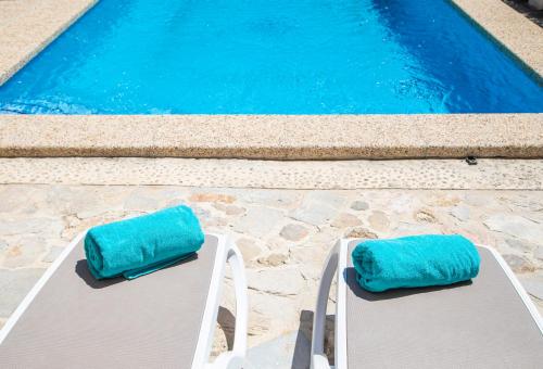 坎帕内特Son Colom Turismo de interior Bed & Breakfast的两把带蓝色靠垫的椅子,位于游泳池旁