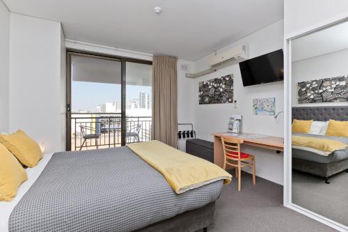 珀斯中央城市独家公寓 的酒店客房设有一张床、一张桌子、一张床和一个窗户。