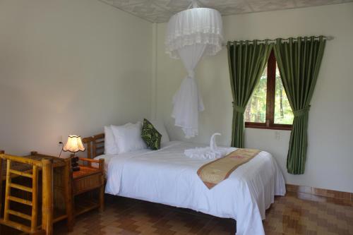 Nguyệt HạngTra Vinh Lodge的一间卧室设有两张床和窗户。