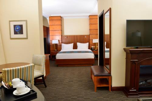 亚的斯亚贝巴The HUB Hotel的配有一张床和一台平面电视的酒店客房
