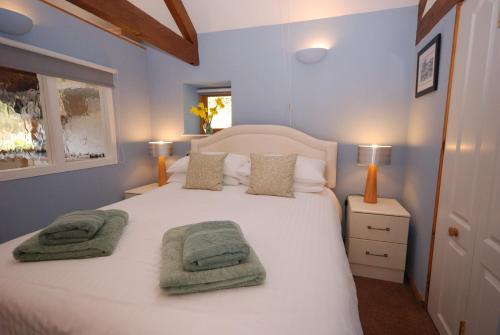 纽基Bowgie at Trewerry Cottages - Away from it all, close to everywhere的卧室配有白色的床和2条毛巾