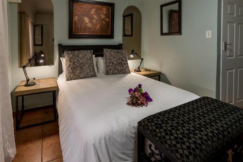 埃尔默洛Izimbali Lodge and Restaurant的一间卧室配有一张白色大床,床上有鲜花