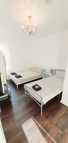 格里姆斯比Regent Guest House的客厅设有两张床,铺有木地板