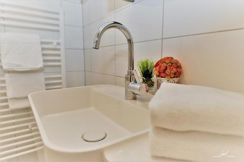 沃尔特湖畔韦尔登克恩顿费尔登酒店的白色浴室内的白色水槽,配有毛巾