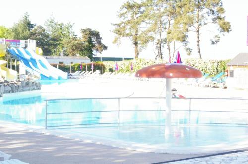 翁赞BVCO LOCATIONS PROCHE CHATEAUX ET BEAUVAL DANS LE LOIR et CHER的一个带遮阳伞和水滑梯的游泳池