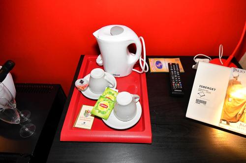 皮亚扎-阿尔梅里纳安提奇夸尔提埃里旅馆的一张桌子,上面有红色的盘子,茶壶和杯子