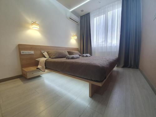 基辅LuxApartment的一间卧室设有一张床和一个大窗户