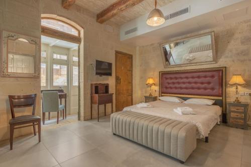 瓦莱塔卢西亚诺艾尔波托精品酒店的一间卧室配有一张大床和红色床头板