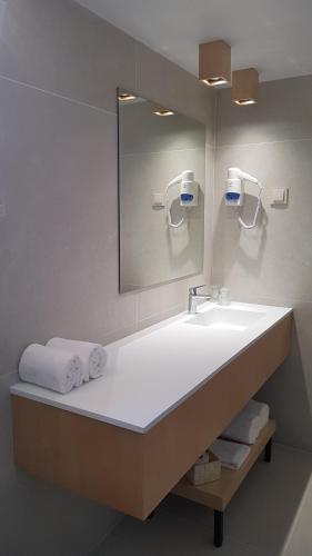 法鲁弗朗加利亚旅馆的浴室配有盥洗盆、镜子和毛巾