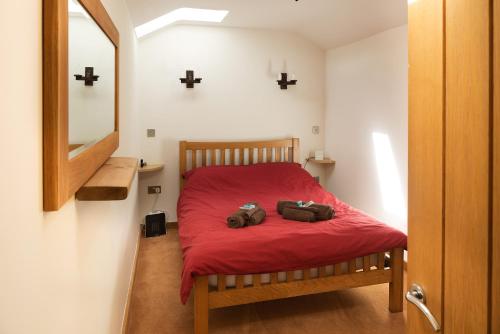 ThorndonOwl's Hoot的一间卧室配有红色的床,上面装有两袋