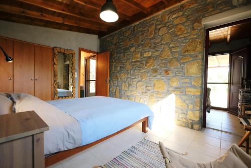 KalliópiLimnos Stone House的一间卧室设有一张床和石墙
