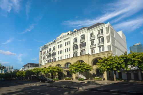 雅加达Hotel Des Indes Menteng的蓝天城市街道上的白色建筑