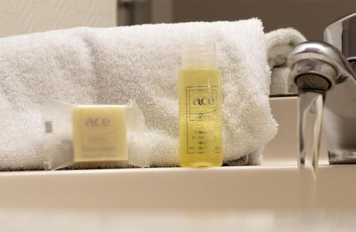 布尔日布尔日艾斯酒店的浴室柜台配有1瓶肥皂和毛巾