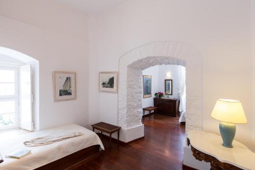 伊兹拉Hotel Miranda的带两张床的房间和石拱门