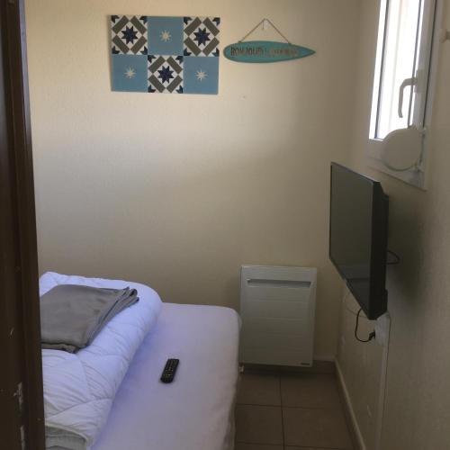 拉卡诺Bleu marine的小房间设有一张床和一台平面电视