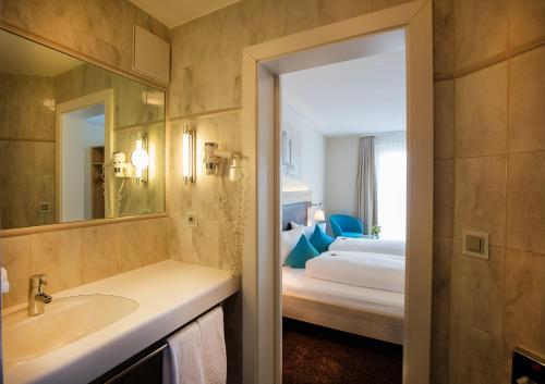 特里森贝格高原酒店的浴室设有床、水槽和镜子
