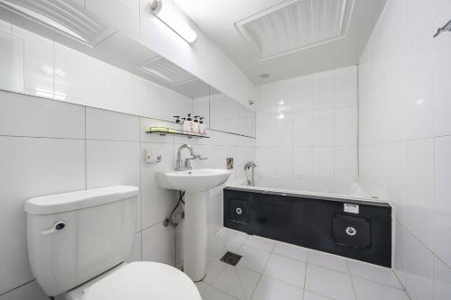 坡州市Q酒店的浴室配有卫生间、盥洗盆和浴缸。