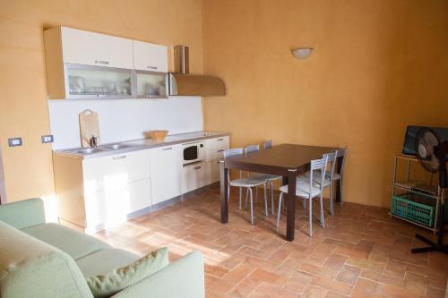 里帕尔贝拉卡萨尔皮诺乡村民宿的厨房以及带桌椅的用餐室。