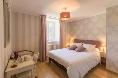 克莱西Le Manoir de Placy - Chambres d'Hôtes的卧室配有一张白色的大床和一张桌子