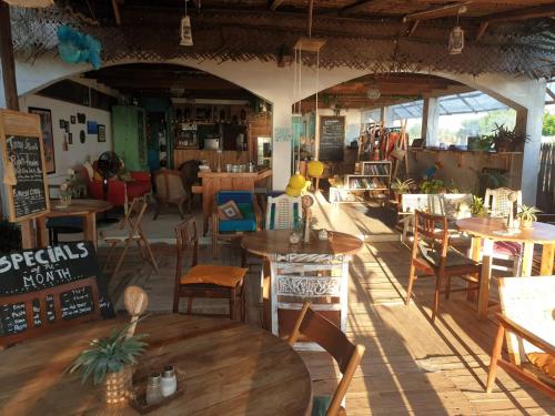 尼拉瓦利Memo's Beach的一间设有木桌和椅子的餐厅