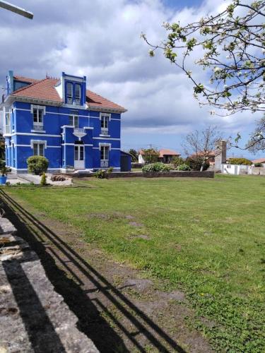 BallotaLa Clinica的前面有绿地的蓝色房子