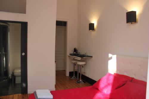 里尔Les Cariatides的卧室配有红色的床和水槽