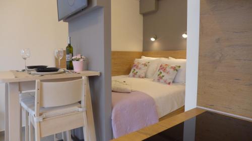 奥帕提亚Studio Claudia的一间小卧室,配有一张床和一张桌子及椅子