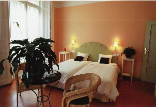 塞哥维亚福尔诺斯旅馆的一间卧室配有一张大床和盆栽植物