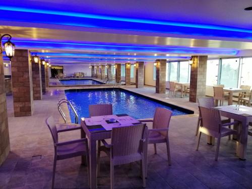 伊尔比德七天酒店的餐厅设有一座带桌椅的游泳池