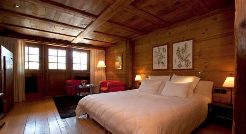 夏蒙尼-勃朗峰哈默阿尔伯特一世酒店的木制客房内的一间卧室配有一张大床