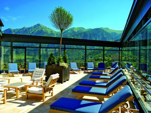 巴德加斯坦萨尔茨堡霍夫酒店的庭院配有躺椅,背景为山脉