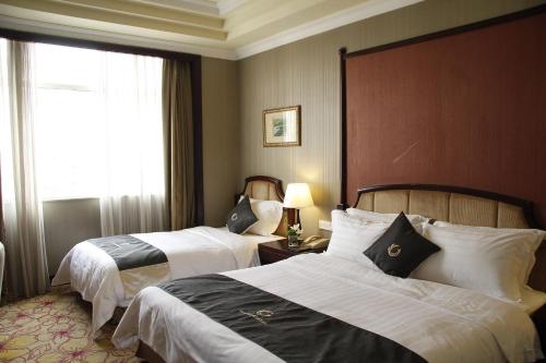广州科尔海悦酒店的酒店客房设有两张床和窗户。
