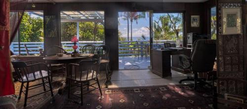 帕霍阿Ma'ukele Lodge的客房设有桌椅和阳台。