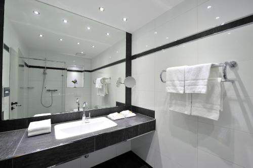 多尔马根霍特耶餐厅酒店的白色的浴室设有水槽和镜子