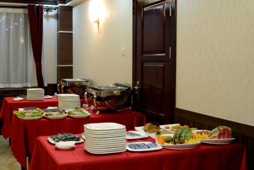乌兰巴托蒙古阿尔法酒店的两个桌子,上面有红色桌布,上面有盘子