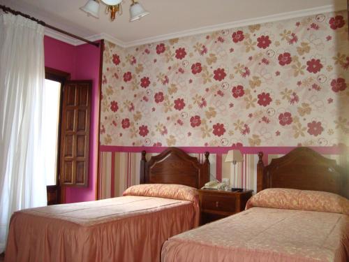 奥耶多佩尼亚萨格拉旅馆的一间卧室设有两张床和花卉壁纸