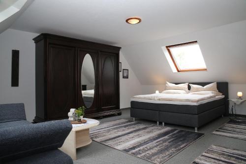 多鲁姆纽菲尔德Ferienwohnung am Schwarzen Wehl的一间卧室配有一张床、一张沙发和一面镜子