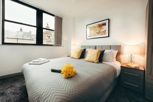 哈利法克斯Halifax House, One Bedroom Apartment 216的一间卧室,床上有黄色的鲜花