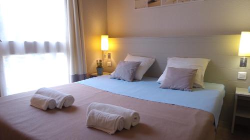 雷岛圣玛丽VVF Île de Ré Sainte-Marie-de-Ré的卧室配有带毛巾的大型白色床