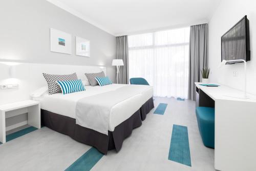 拉克鲁斯Hotel Blue Sea Interpalace的酒店客房设有一张大床和一台电视。