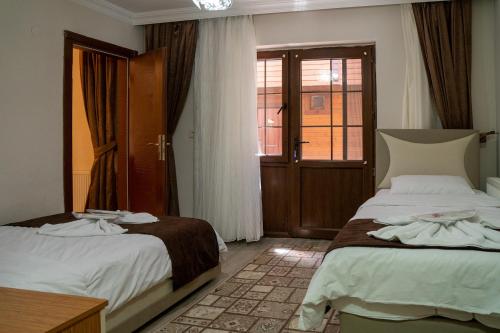 乌宗Kuzey Park Hotel的酒店客房设有两张床和窗户。