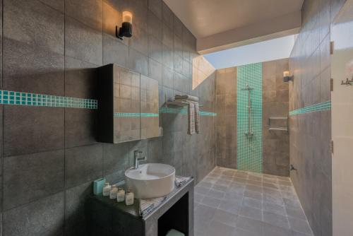 迪古拉海滩潜水全包精品酒店的一间带水槽和淋浴的浴室