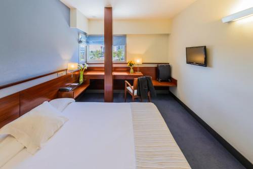 托雷洪-德阿尔多斯托雷洪旅馆的一间卧室配有一张床、一张书桌和一台电视