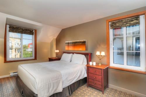 蒙特朗布朗圣伯纳德特拉姆布朗特山酒店的一间卧室设有一张床和两个窗户。