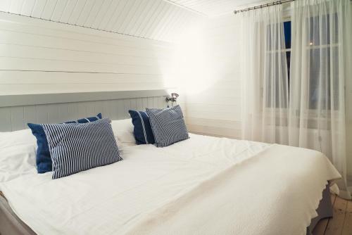 Klädesholmen索尔特 & 希尔酒店的一张带蓝色枕头的白色床和窗户