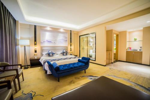 昆明德美精品酒店（同德广场店）的一间卧室配有一张大床和一张蓝色的沙发