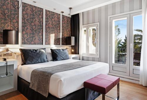 隆达雷纳维多利亚加泰罗尼亚酒店的一间卧室设有一张大床和一个窗户。